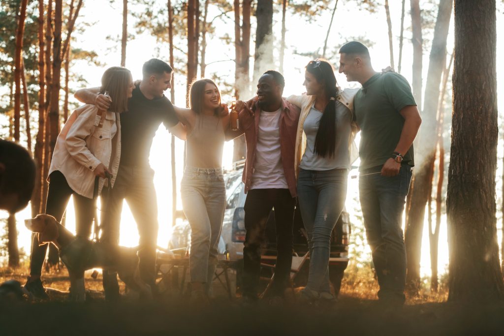 Embracing each other. Group of friends are having fun together in the forest Embracing each other. Group of friends are having fun together in the forest