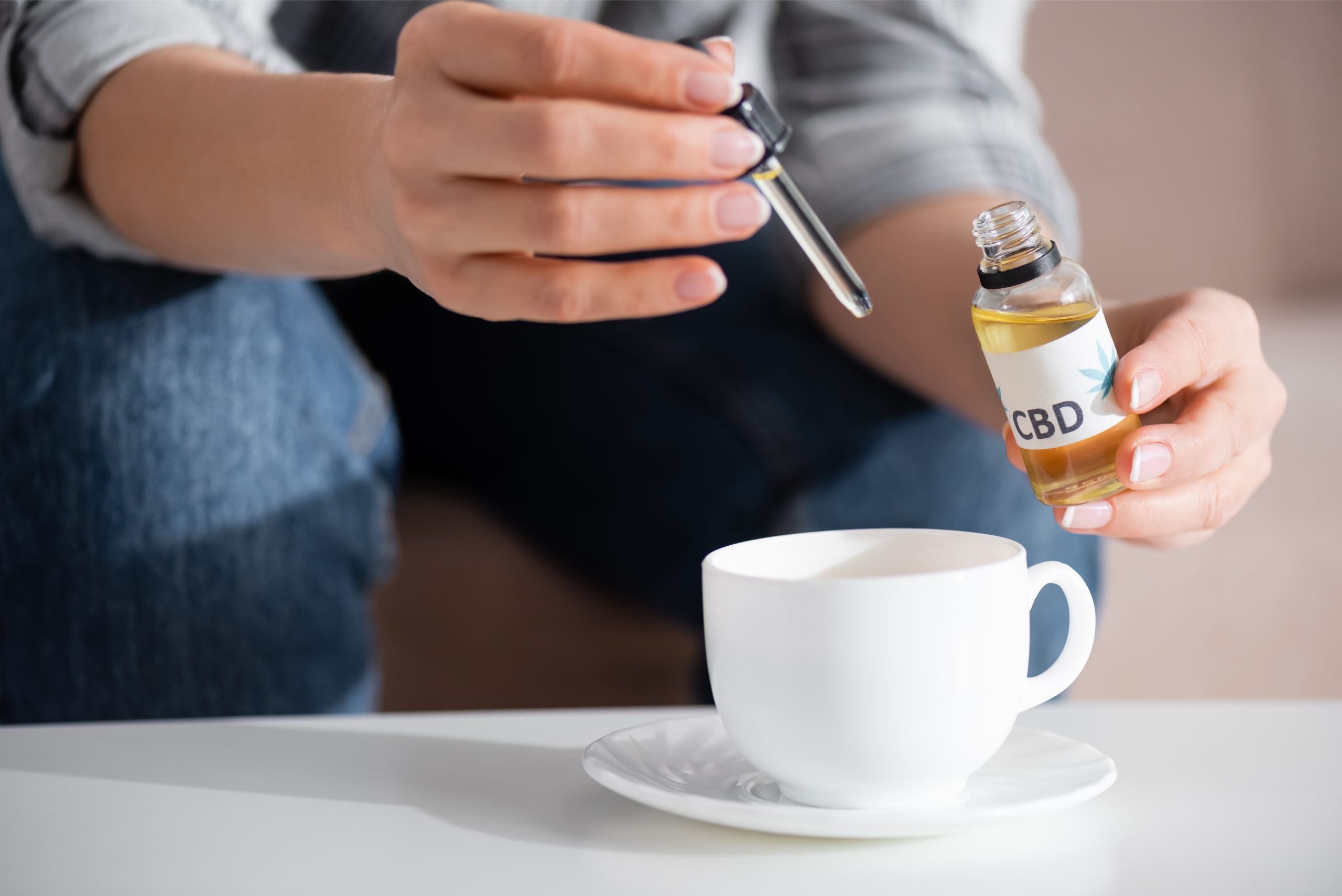 cropped view of mature woman adding cbd in cup of tea Pessoa usando medicando com CBD