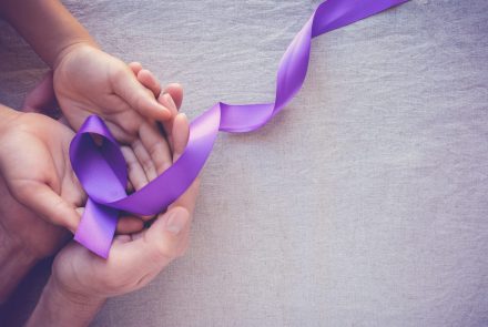hands-holding-purple-ribbons-alzheimer-disease-epilepsy-awareness-scaled-1.jpg