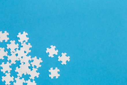White puzzles on a blue background, flat lay, conceptual minimalism, copy space.